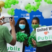 Two women holding a sign that reads "United Way Loves Publix"