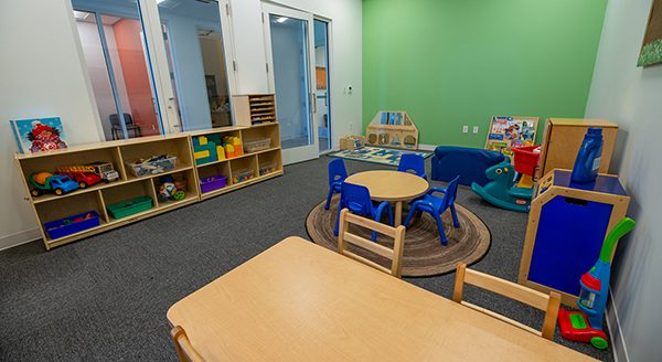 visitation room setup with children's furniture, toys and colorful walls.